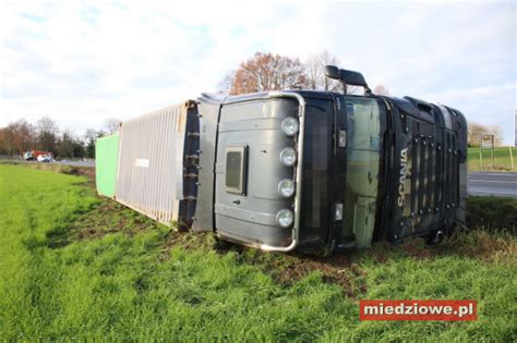 Zdjęcie z miejsca wypadku: przewrócony ciągnik rolniczy w rowie i ciężarowa Scania na drodze.