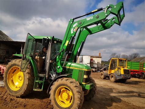 ładowacz czołowy John Deere 603R zamontowany na ciągniku w polu