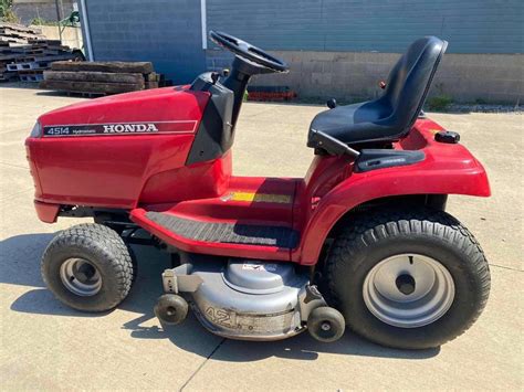 Thematic photo of a Honda lawn tractor with headlights on during twilight