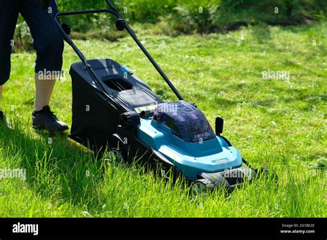 Thematic photo of a well-maintained green lawn with an electric lawnmower