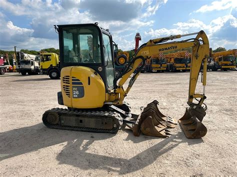Schematyczne przedstawienie minikoparki Komatsu PC26MR-3 z zaznaczonym zerowym promieniem obrotu podwozia