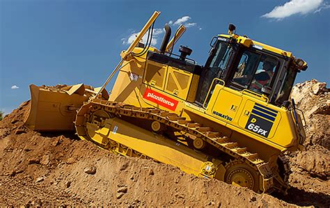 Zdjęcie przedstawiające spycharkę gąsienicową Komatsu D65 w trakcie pracy na placu budowy.