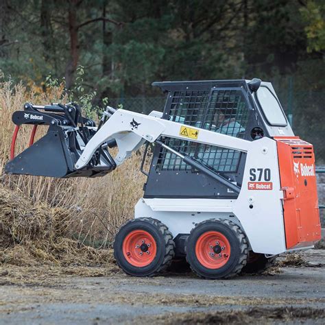 Zdjęcie ładowarki typu skid-steer (Bobcat) pracującej na placu budowy
