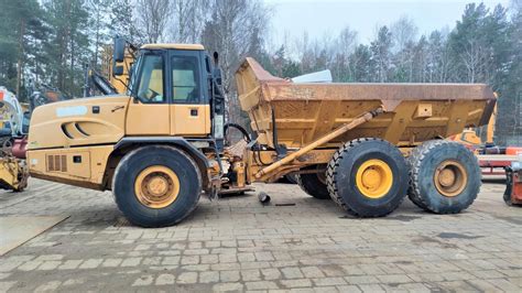 Zdjęcie przedstawiające wozidło przegubowe Caterpillar 730 pracujące w trudnym terenie kopalnianym