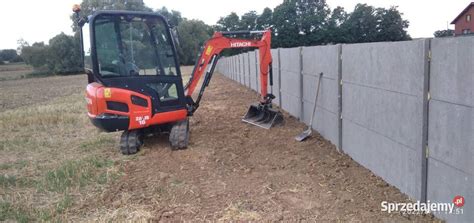 minikoparka wykonująca wykopy w ogrodzie lub na małej działce budowlanej