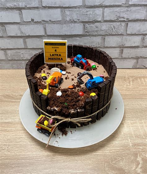 Tort przedstawiający miniaturowy plac budowy z cukrowymi narzędziami i maszynami