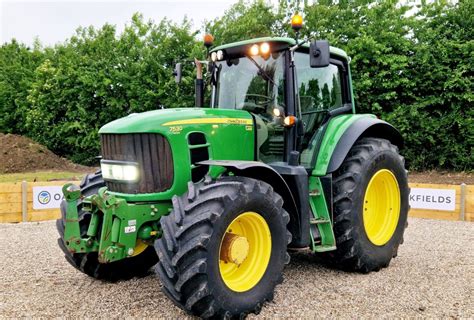 Zdjęcie przedstawiające ciągnik John Deere 6410 w polu podczas pracy