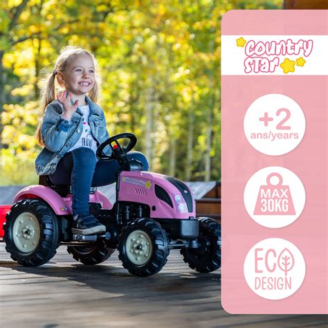 The Falk Country Star pink pedal tractor with a trailer, driven by a child in a garden setting.