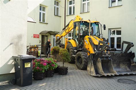 Tematyczne zdjęcie przedstawiające koparko-ładowarkę w pracy