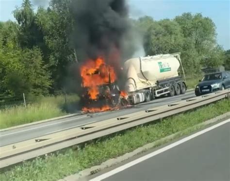 Strażacy gaszący pożar ciągnika siodłowego na poboczu drogi