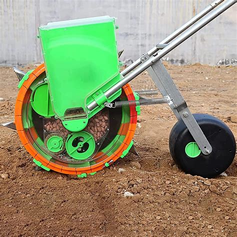 Thematic photo of a person using a wheeled garden seeder