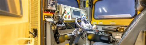 wnętrze kabiny JCB 403 z ergonomicznym joystickiem i panelem sterowania