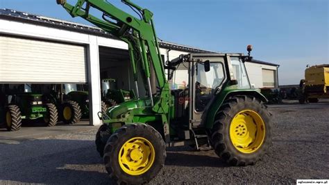 Zdjęcie ciągnika John Deere 3400 z zamontowanym ładowaczem czołowym, pracującego w gospodarstwie rolnym