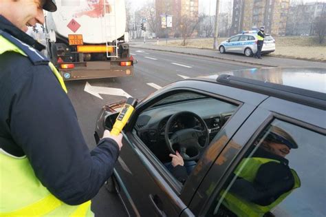 Policjant kontrolujący trzeźwość kierowcy ciągnika rolniczego na drodze gruntowej