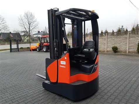 Thematic photo of a reach truck (wozek widlowy RAK) operating in a narrow warehouse aisle