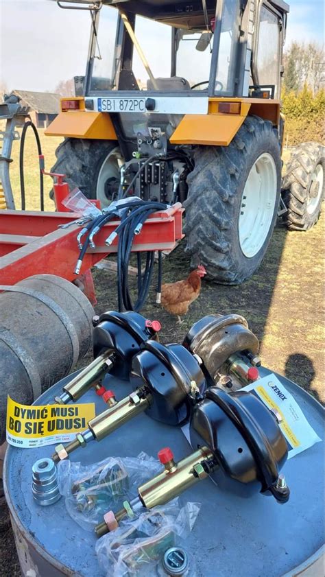 Infografika przedstawiająca mechanizm wywrotu trójstronnego w przyczepie rolniczej