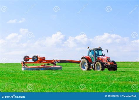 Thematic photo of a rotary mower attached to a tractor working in a field