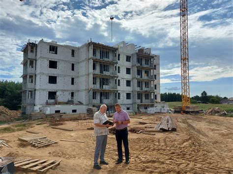 Zdjęcie przedstawiające nowoczesny plac budowy z pracującą koparko-ładowarką.