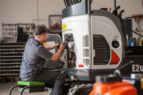 Photo of a technician performing maintenance on a Bobcat mini-excavator