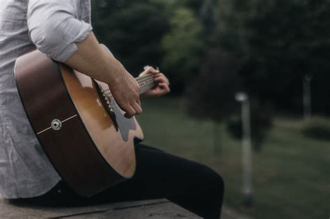 osoba grająca na gitarze i śpiewająca pieśń religijną