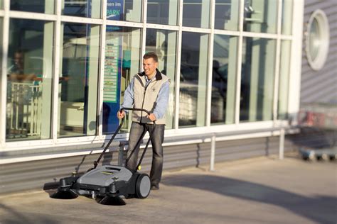 Operator zamiatarki przeprowadzający kontrolę płynów