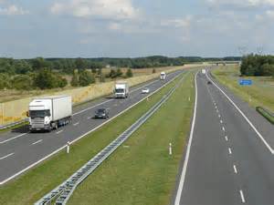 Zdjęcie przedstawiające rozlaną płynną czekoladę na pasie ruchu autostrady A2 oraz przewróconą cysternę