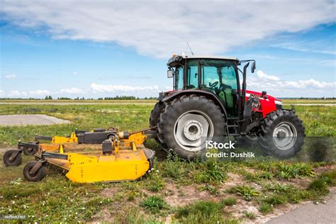 Zdjecie ciągnika Massey Ferguson 110 z podłączoną małą kosiarką rotacyjną na polu.