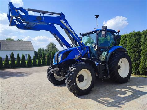 Ciągnik New Holland T6 z zamontowanym ładowaczem czołowym i widocznym układem hydraulicznym