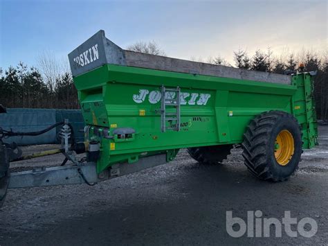 Zdjęcie rozrzutnika Joskin Tornado 3 z widoczną wąską skrzynią i kołami o dużej średnicy