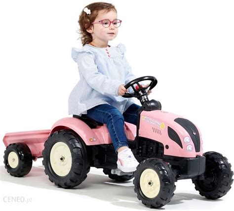 zdjęcie dziecka jadącego traktorkiem na pedały w ogrodzie