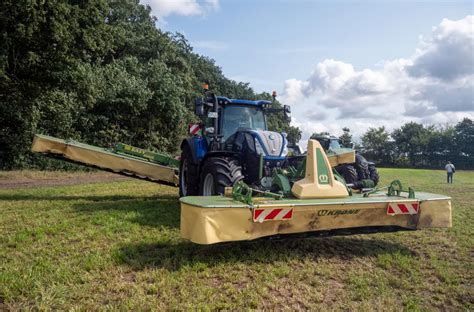 Rolnik użytkujący kosiarkę dyskową Krone na polu