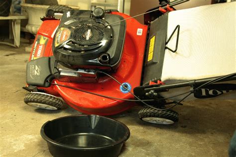 Thematic photo showing maintenance of a petrol lawnmower, e.g., changing oil or sharpening blade