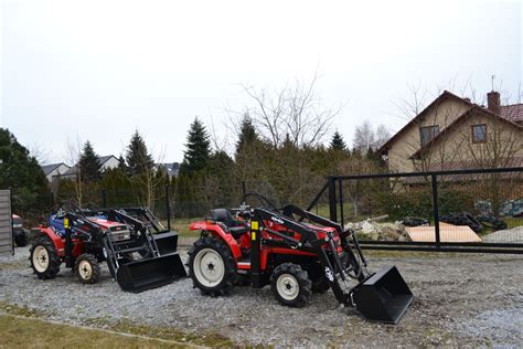 Zestawienie różnych modeli ciągników z zamontowanymi ładowaczami czołowymi na placu wystawowym