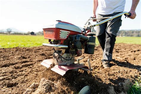 Thematic photo of a person operating a garden tiller in a field