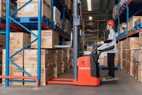 Thematic photo of a small electric forklift lifting a light load in a warehouse aisle