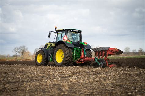 Thematyczne zdjęcie nowoczesnego ciągnika John Deere 6155M w pracy na polu