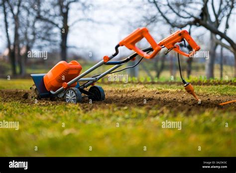 Thematic photo of a rotary tiller with separator preparing soil in a garden.