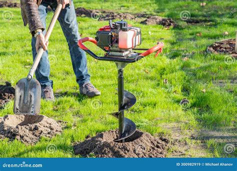 Thematic photo of a powerful soil auger in operation, drilling a hole for a fence post