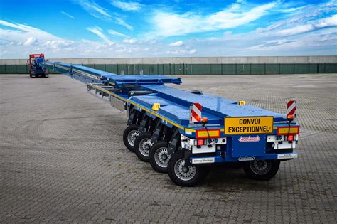 Naczepa Nooteboom OSDS-44-03 z muldami na koła transportująca ładowarkę