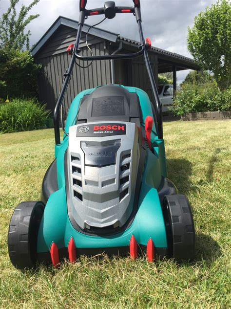 Zdjęcie przedstawiające kosiarkę Bosch Rotak 43 LI w przydomowym ogrodzie
