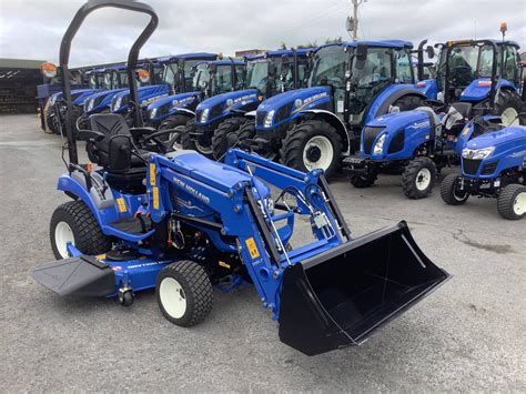 The New Holland 105 LC front loader attached to a New Holland Boomer 25 C tractor, showcasing its robust design and quick attach/detach mechanism.