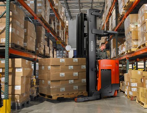Thematic photo of a high-reach forklift (reach truck) operating in a narrow aisle of a warehouse with high shelves.