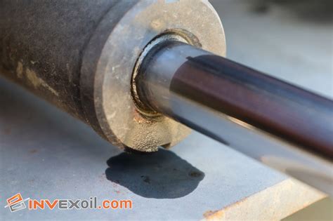 Thematic photo of a hydraulic cylinder on a construction machine with visible oil leaks