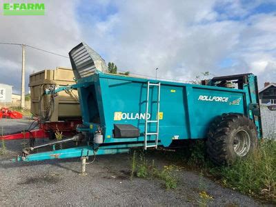 Zdjęcie rozrzutnika Rolland Rollforce w charakterystycznych barwach niebiesko-żółtych, prezentujące ogólny wygląd maszyny w polu