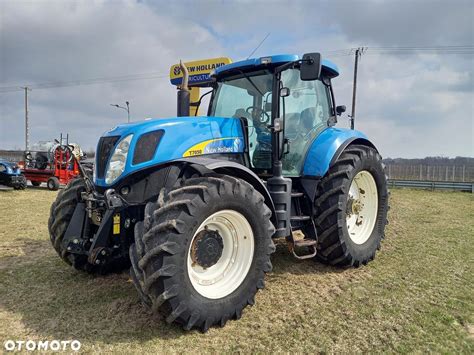 Tematyczne zdjęcie przedstawiające różnorodne maszyny rolnicze New Holland w polu