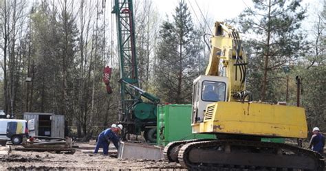 Zilustruj wiertnicę glebową w akcji, wykonującą otwór w ziemi