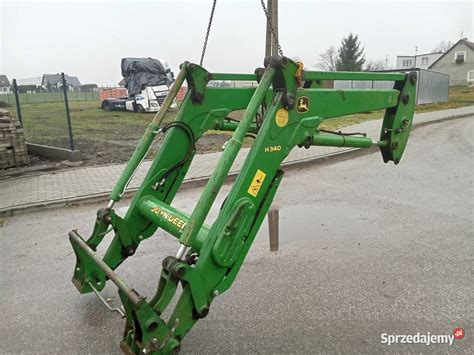 Zbliżenie na funkcjonalny ładowacz czołowy zamontowany na traktorze John Deere