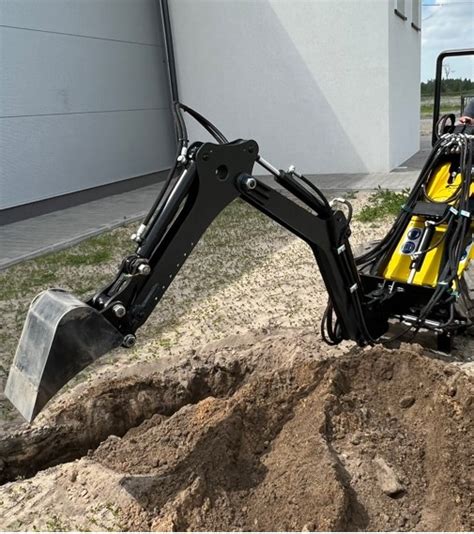 Schemat koparko-ładowarki z zaznaczonymi elementami roboczymi (łyżka przednia, ramię kopiące tylne)