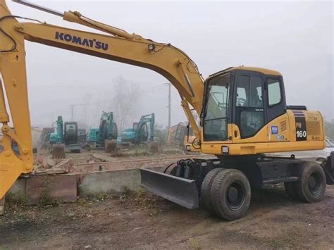Zdjęcie przedstawiające koparkę kołową Komatsu PW160 podczas prac ziemnych