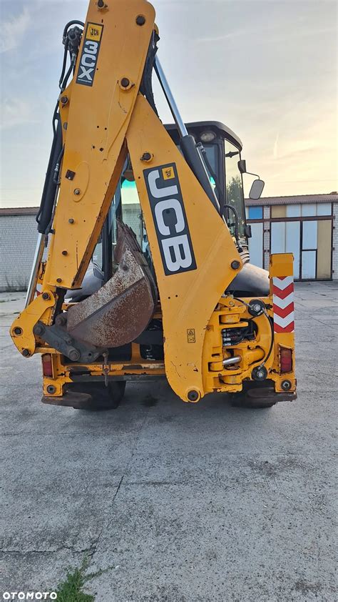 Ilustracja przedstawiająca koparko-ładowarkę JCB 3CX w akcji na placu budowy.